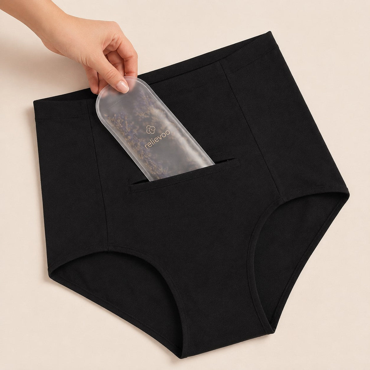 Hand sliding the hot and cold therapy pack into the hidden front pocket of the postpartum brief