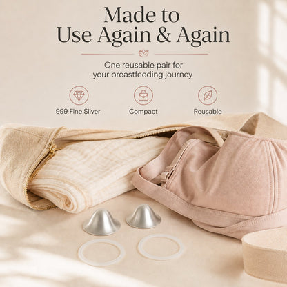 One reusable pair of silver nursing cups and two rings laid beside a folded muslin and a soft changing bag rvpumpen rvhasar
