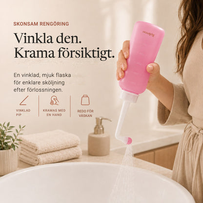 Hand squeezing the pink 350 ml Relievoo peri bottle with its angled nozzle rvpumpen rvhasar