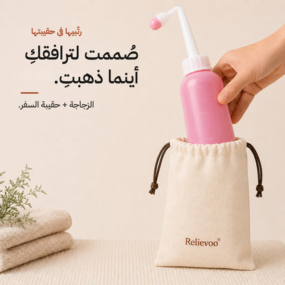 Relievoo peri bottle being placed into its cotton drawstring travel pouch beside folded towels